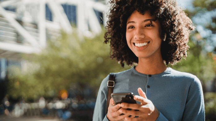 Woman smiling while using mobile phone