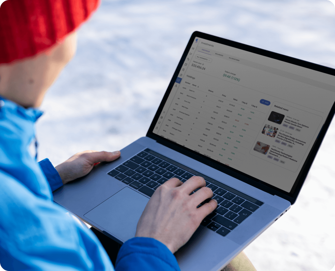 A person in a jacket using Quicken software on their laptop while outside.